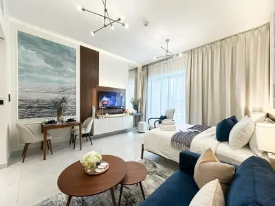 a bedroom with a bed and a living room at Trophy - Santorini Studio BurjKhalifa & Canal Views Sofa Bed in Dubai