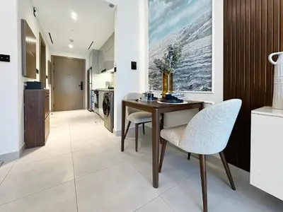 a kitchen with a dining room table and chairs at Trophy - Santorini Studio BurjKhalifa & Canal Views Sofa Bed in Dubai