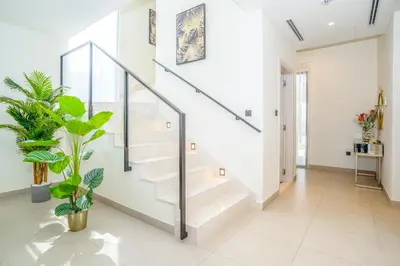 a white staircase in a house with plants at New Arabian Dubai Hills villa- 3 BR & Maid Golf Grove With Private pool in Dubai
