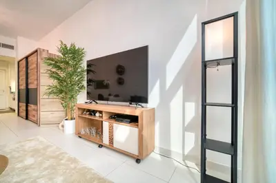 a living room with a tv on a wall at Studio in Palm Views West at Palm Jumeirah by PK Holidays in Dubai