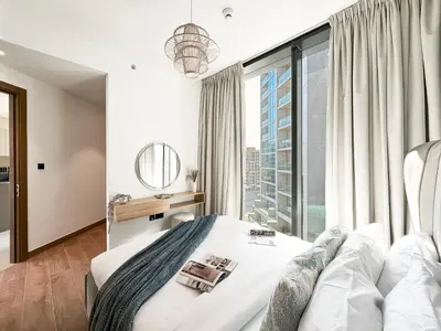 a bedroom with a bed and a large window at Trophy - Alfresco 2BDR Suite in Dubai