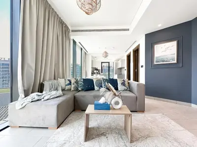 a living room with a couch and a table at Trophy - Alfresco 2BDR Suite in Dubai