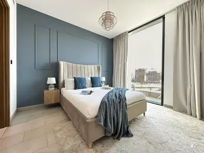 a bedroom with a large bed with blue walls at Trophy - Alfresco 2BDR Suite in Dubai