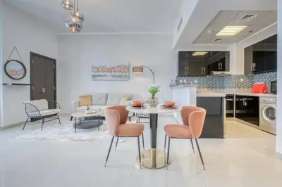 a kitchen and living room with a table and chairs at Spacious 1BR in Botanica tower with sea view by PK holidays in Dubai