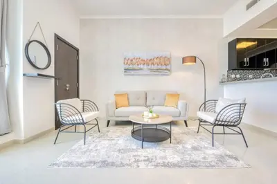 a living room with a couch and chairs at Spacious 1BR in Botanica tower with sea view by PK holidays in Dubai