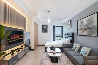 a living room with a couch and a bed at Modern Studio Lake View JLT Near Marina & Metro in Dubai