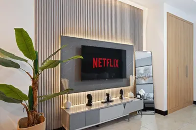a living room with a tv on a wall at Modern Studio Lake View JLT Near Marina & Metro in Dubai