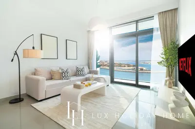 a living room with a white couch and a table at LUX The Beachfront Island View Suite in Dubai