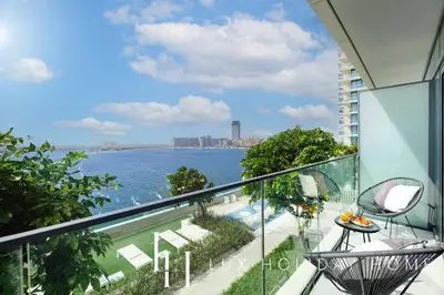 an apartment balcony with a view of the water at LUX The Beachfront Island View Suite in Dubai