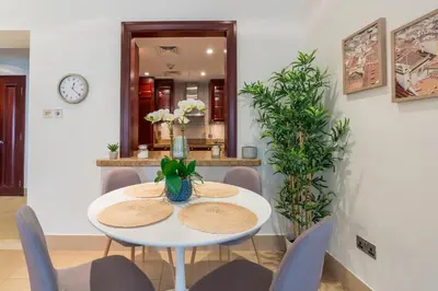 a white dining room with a white table and chairs at Spacious 2Bedroom with Burj View in Downtown Dubai in Dubai