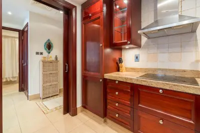 a kitchen with wooden cabinets and a sink at Spacious 2Bedroom with Burj View in Downtown Dubai in Dubai