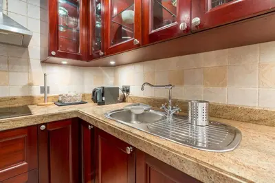a kitchen counter with a sink and aounter at Spacious 2Bedroom with Burj View in Downtown Dubai in Dubai