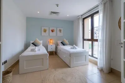a white bedroom with a bed and a window at Spacious 2Bedroom with Burj View in Downtown Dubai in Dubai