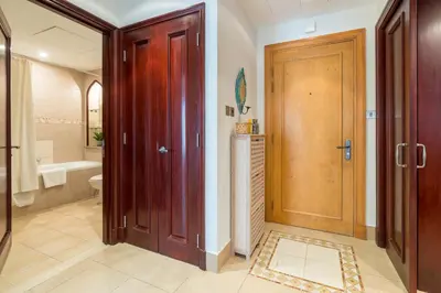 a bathroom with a toilet and a wooden door at Spacious 2Bedroom with Burj View in Downtown Dubai in Dubai