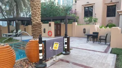 a patio with a pool and a table and a palm tree at Spacious 2Bedroom with Burj View in Downtown Dubai in Dubai