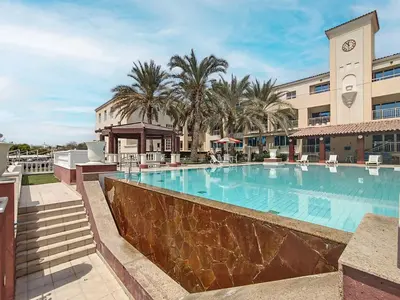 a large swimming pool in front of a hotel at Lake Apartments - 1BR Apartment - Allsopp&Allsopp in Dubai