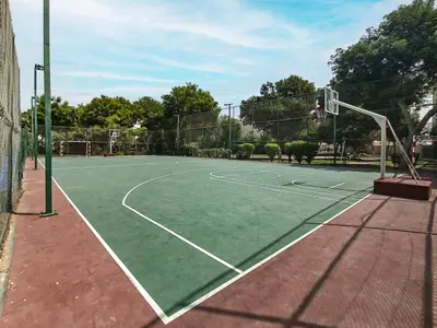 a tennis court with a net and a basketball hoop at Lake Apartments - 1BR Apartment - Allsopp&Allsopp in Dubai