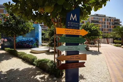 a street sign with arrows pointing in different directions at Serene 1BR at Afnan 3 Midtown Dubai Production City by Deluxe Holiday Homes in Dubai
