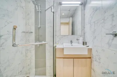 a bathroom with a shower and a sink and a mirror at Serene 1BR at Afnan 3 Midtown Dubai Production City by Deluxe Holiday Homes in Dubai