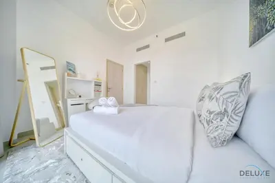 a white bedroom with a bed and a mirror at Serene 1BR at Afnan 3 Midtown Dubai Production City by Deluxe Holiday Homes in Dubai