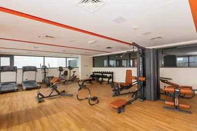 a gym with several exercise equipment in a room at Serene 1BR at Afnan 3 Midtown Dubai Production City by Deluxe Holiday Homes in Dubai