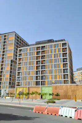 a large apartment building on a city street at Serene 1BR at Afnan 3 Midtown Dubai Production City by Deluxe Holiday Homes in Dubai