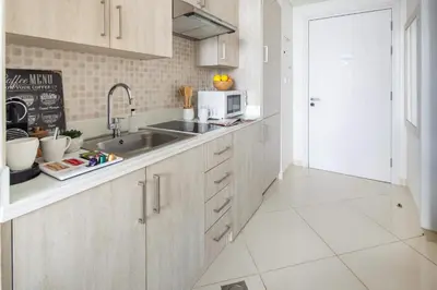 a kitchen with white cabinets and a sink at Frank Porter - Seven Hotel & Aprtments in Dubai