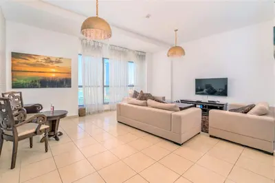 a living room with two couches and a tv at Stunning Beach front Apt Dubai Eye View JBR Dubai in Dubai