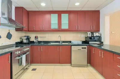 a kitchen with red cabinets and a sink at Stunning Beach front Apt Dubai Eye View JBR Dubai in Dubai