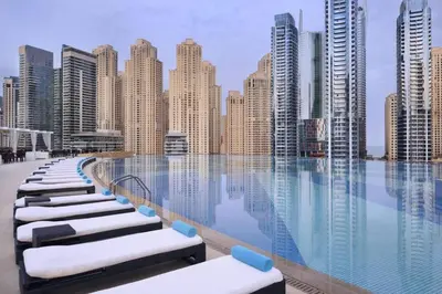 a pool with a view of a city with tall buildings at The Refined in Dubai