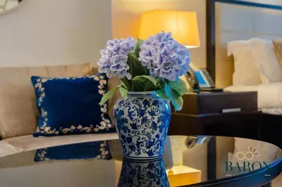 a blue and white vase with purple flowers on a table at The Refined in Dubai