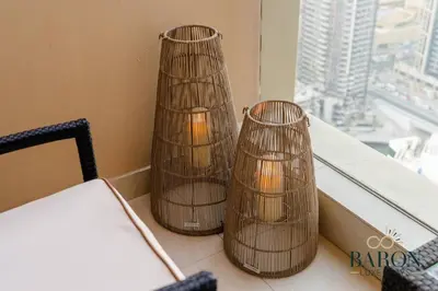 two candle holders sitting on a table near a window at The Refined in Dubai