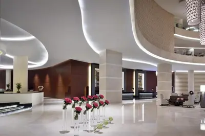 a lobby with red roses in vases on the floor at The Urban in Dubai