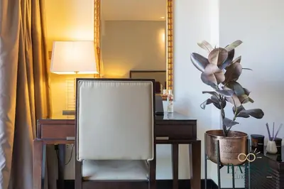a chair sitting next to a desk with a mirror at The Urban in Dubai