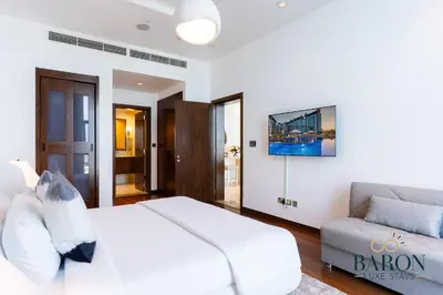 a white bedroom with a bed and a couch at The Grand Palm Suite Oceana in Dubai