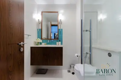 a bathroom with a shower and a toilet and a sink at The Grand Palm Suite Oceana in Dubai