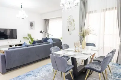a living room with a couch and a table and chairs at Shams Beach Front JBR apartments by HAPPY SEASON in Dubai