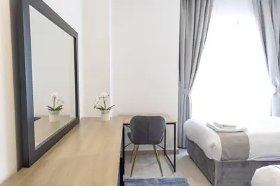 a bedroom with a bed and a desk and a mirror at Shams Beach Front JBR apartments by HAPPY SEASON in Dubai