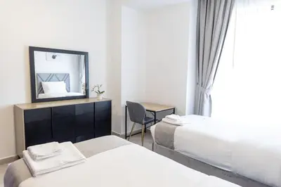 a hotel room with two beds and a mirror at Shams Beach Front JBR apartments by HAPPY SEASON in Dubai