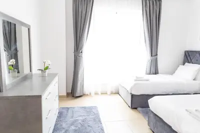 a bedroom with two beds and a dresser and a mirror at Shams Beach Front JBR apartments by HAPPY SEASON in Dubai