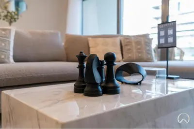 a chess game on a coffee table in a living room at Oraya - Stunning 2BR- Mulberry Dubai Hills, Pool-Park view in Dubai