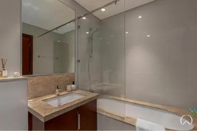 a bathroom with a sink and a glass shower at Oraya - Stunning 2BR- Mulberry Dubai Hills, Pool-Park view in Dubai