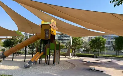 a playground with a slide in a park at Oraya - Stunning 2BR- Mulberry Dubai Hills, Pool-Park view in Dubai