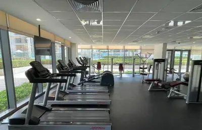 a gym with a row of treadms and machines at Oraya - Stunning 2BR- Mulberry Dubai Hills, Pool-Park view in Dubai