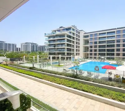 a swimming pool in front of a large building at Oraya - Stunning 2BR- Mulberry Dubai Hills, Pool-Park view in Dubai
