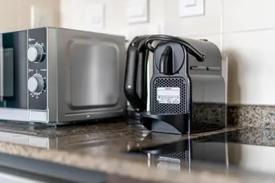 a black toaster sitting on a counter next to a microwave at GuestReady - Full Marina View at Bay Central in Dubai