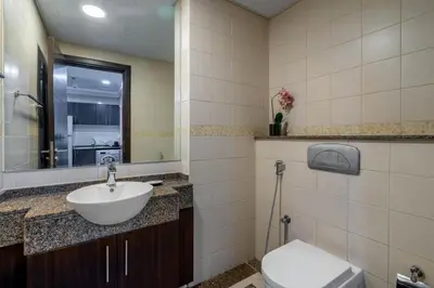a bathroom with a sink and a toilet and a mirror at GuestReady - Full Marina View at Bay Central in Dubai