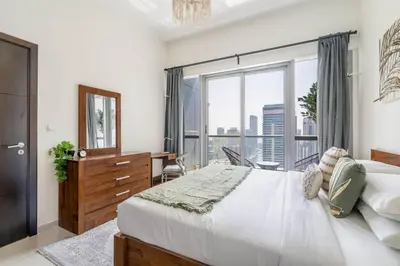 a bedroom with a large bed and a large window at GuestReady - Full Marina View at Bay Central in Dubai