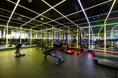 a gym with several treadmills and machines in a room at Daniels Cozy Studio at JVC in Dubai
