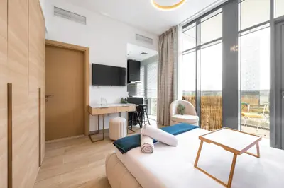 a bedroom with a bed and a desk in a room at Daniels Cozy Studio at JVC in Dubai
